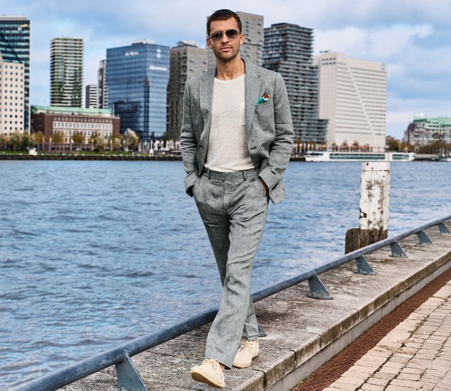 Bild links: Mann bekleidet mit einem grauen Leinenanzug und einer Sonnenbrille schlendert an einem Fluss vorbei; im Hintergrund ist die Skyline einer Stadt zu sehen.
Bild rechts: Detailaufnahme eines grauen Leinenanzugs
