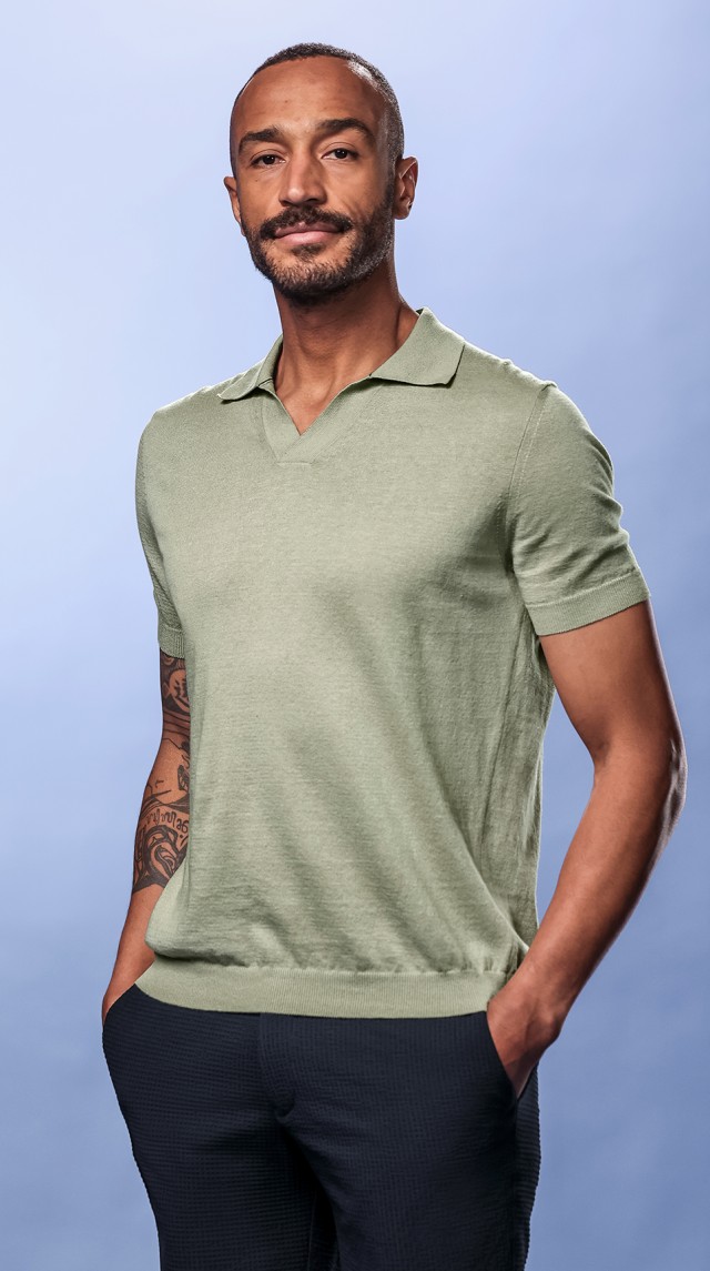 Ein Mann trägt ein beiges Poloshirt und schaut in die Kamera.