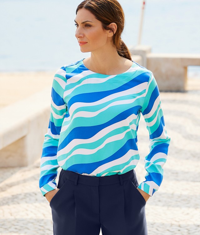 Frau trägt eine auffällige Shirt-Bluse mit Wellenformen. 