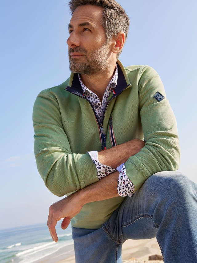 Mann in grüner Fleece Jacke am Strand