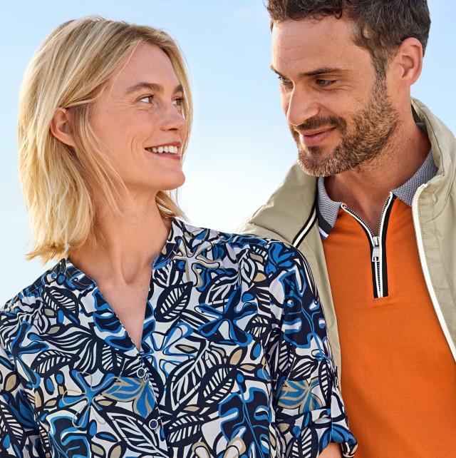 Frau und Mann in luftiger Kleidung am Meer.