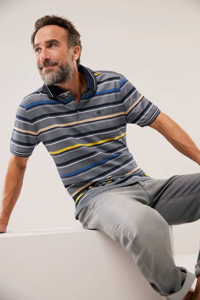 Mann in einem gelb-blau-gestreiften Flex-Polohemd.