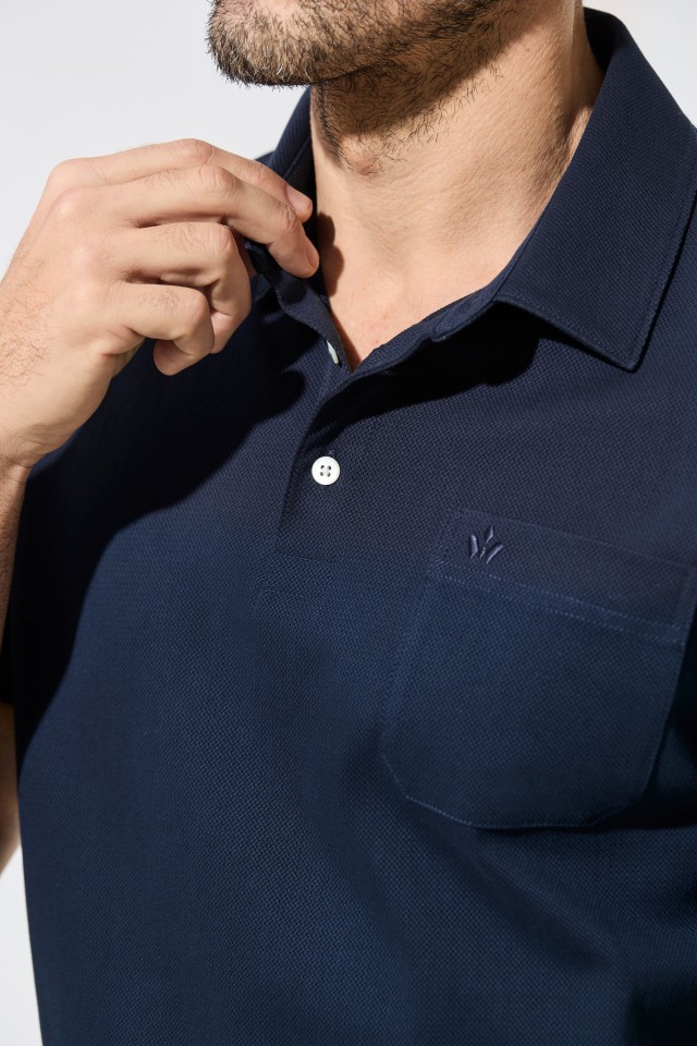 Nahaufnahme eines Mannes in einem dunkelblauen Polohemd.