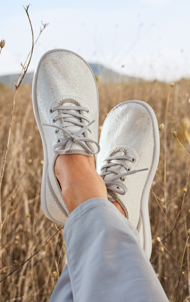 Schnürschuhe in Perlmuttfarbe kombiniert mit einer hellblauen Jeans.